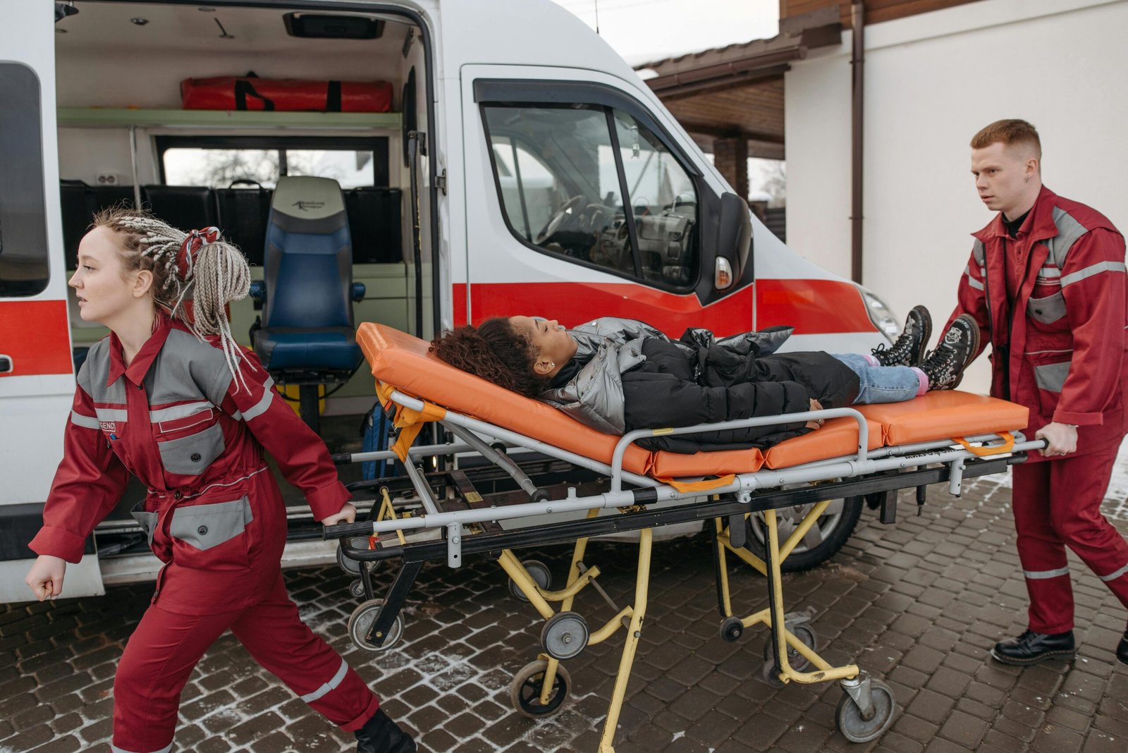 EMTs assist a patient on a stretcher into an ambulance, highlighting emergency response.